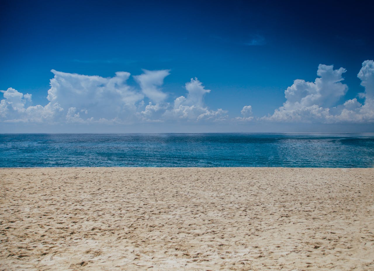 A tranquil beach scene with clear skies and gentle ocean waves, perfect for relaxation.